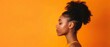 Afro girl in profile with big bun haircut, isolated orange background