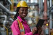 © Georgii - Confident female engineer smiling with tablet in industrial setting