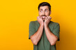 Photo of guilty scared man wear khaki t-shirt biting fingers looking empty space isolated yellow color background