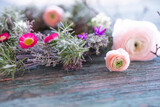 Fototapeta Tulipany - Spring floristry with herbs and flowers on weathered wood. Natural spring decoration with short depth of field.