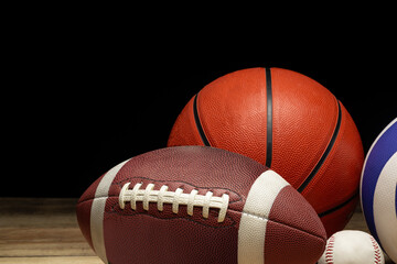 Wall Mural - Set of various sport balls on wooden floor on black background