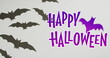 Happy halloween text banner with bat icon against multiple bat toys on grey surface
