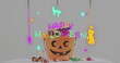 Neon happy halloween text banner against pumpkin shaped bucket full of halloween candies