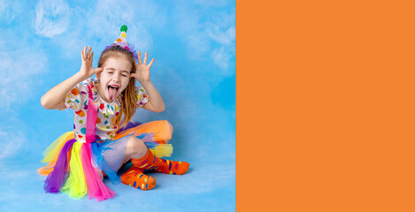 Wall Mural - Funny kid clown playing against a bright wall. 1 April Fool's day concept, birthday concept