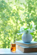 turkish glass tea cup, Jasmine flowers and book on table in garden, abstract natural background. spring summer season. beautiful romantic composition. reading, relax, tea time.