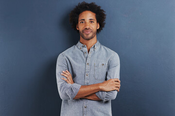 Happy man, portrait and arms crossed in studio as professional, confident and fashion by blue background. African person, face and smile for ambition as designer and creativity or pride in mock up