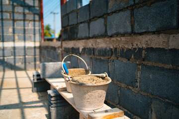 Wall Mural -  brick wall with a bucket of cement