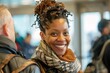 Black woman with a cheerful grin, engaging in conversation with fellow passengers as they await boarding at the gate