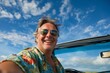 © Maelgoa - A smiling senior man embarking on a summer vacation journey by car, ready to hit the open road, with a vibrant blue sky in the background