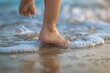 Close-up of a child's bare feet sinking into the warm sand as they stroll along the water's edge, the gentle rhythm of the waves providing a soothing backdrop to their beachside adventure