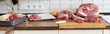 Different tipes of meat,  cutting fresh raw meat on  board in white kitchen. Preparing pork meat, cooking, banner.