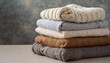 Stack of clean knitted sweaters folded on table. Woolen clothes.