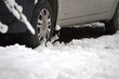 little kitten hidden under the car in the winter in the snow