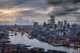 Fototapeta Londyn - Panoramic view of the 2024 skyline of London with City, Tower Bridge and skyscrapers during a moody evening with clouds