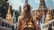 Rear view of  woman with a yellow backpack is walking down on the temple of Thai