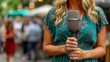 Female Reporter Holding Microphone on Street
