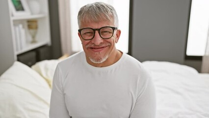 Poster - Hilarious middle-aged grey-haired man pulling a crazy face in his bedroom. puffing cheeks full of air, wearing cosy pyjamas, creating a comical expression.