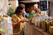 Green living woman in zero waste store interested in purchasing bulk products with high nutritional value. Client does pantry staples shopping in sustainable local neighborhood supermarket