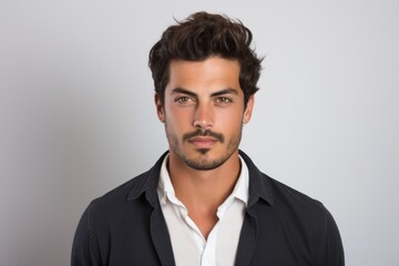 Wall Mural - Portrait of a handsome young man in a black shirt, over grey background.