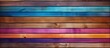 A detailed picture of a wooden wall showcasing a variety of vibrant colors including purple, pink, violet, and magenta, possibly from wood stain or flooring tints and shades