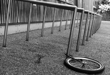 Abandoned Bicycle Wheel Chained To A Bike Rack