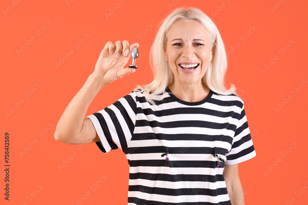 Mature woman with anal plug on red background