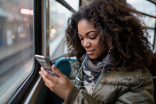 Young Woman Using Smartphone On Public Transport
