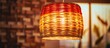 © Lasvu - Abstract red and yellow artwork with bamboo pattern design on lamp shade. Perspective rattan lamp hanging from ceiling in interior and lighting design