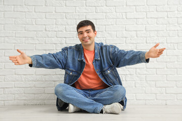 Sticker - Young man opening arms for hug near white brick wall