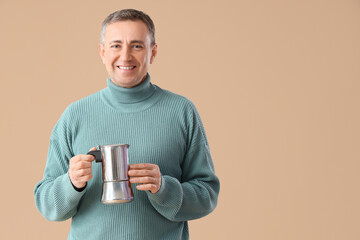 Canvas Print - Mature man with geyser coffee maker on beige background