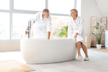 Wall Mural - Mature couple preparing bathtub in bathroom