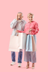 Poster - Mature woman with shopping bags and her shocked husband on pink background