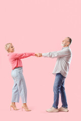 Poster - Mature couple dancing on pink background