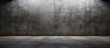 An empty room with a concrete floor and wall, resembling the tints and shades of a grey monochrome photograph, under a cloudy sky