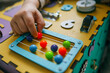 © shine.graphics - Busy Board. A child plays with pleasure with a toy model at home, which is intended for the development of fine motor skills