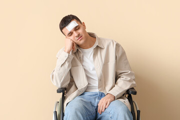 Sticker - Young man with brain concussion in wheelchair on beige background