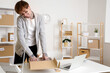 © Pixel-Shot - Young online store seller with parcel talking by telephone at table in warehouse
