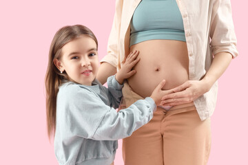 Poster - Little girl with her pregnant mother on pink background