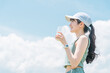 © buritora - 青空の下で運動中にプロテインを飲む若いアジア人女性