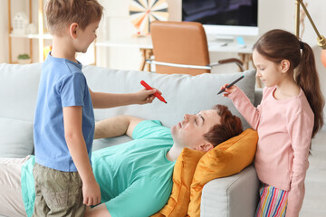 Sticker - Little children painting face of their sleeping father at home. April Fool's Day prank