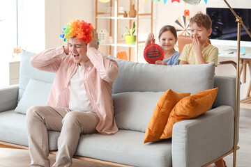 Sticker - Little children surprising their father with whoopee cushion at home. April Fool's Day prank