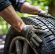 a spring scenery, in which a professional good looking mechanic is mounting super clean summer tires onto a vehicle, the image should convey positivity, sunshine and trustworthiness