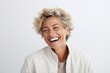 Portrait of happy mature woman with short blond hair laughing against white background