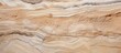 A closeup image capturing the intricate pattern of beige and brown wood with a marble texture. The hardwood formation resembles bedrock outcrop in a landscape