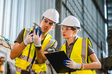 Wall Mural - woman engineer in uniform helmet inspection check control heavy machine robot arm construction installation in industrial factory. technician worker check for repair maintenance electronic operation