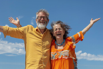 Sticker - A couple smiling and celebrating with their arms outstretched against the blue sky