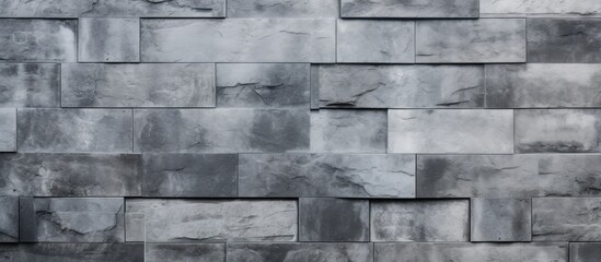 Poster - A closeup of a grey brick wall with a geometric pattern, showcasing the rectangular bricks and intricate brickwork on the building facade