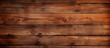 A close up of a hardwood brown plank wall with an amber wood stain, showcasing the beautiful pattern of the rectangular wood flooring. Tints and shades create a stunning blurred background