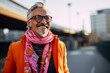 Cheerful senior man with glasses and a pink scarf in the city