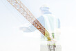 © Kwangmoozaa - Double exposure image of professional engineer in protective helmet and blueprints paper at building construction site